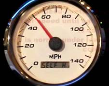 A photo of a beautiful analogue speedo, shiny chrome with beige background, red needle